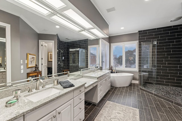 bathroom with ornamental molding, shower with separate bathtub, a skylight, and vanity