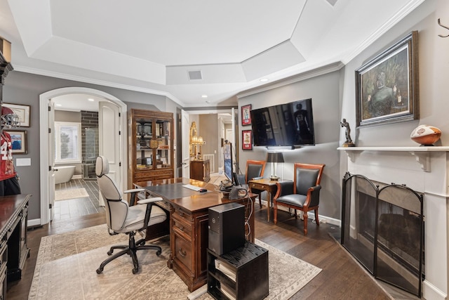 office with crown molding, dark hardwood / wood-style flooring, and a raised ceiling