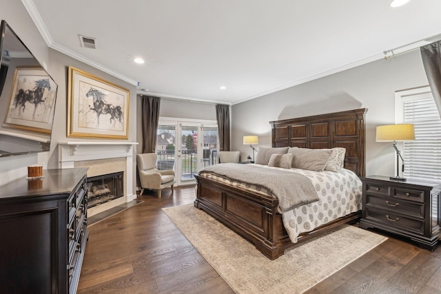 bedroom featuring crown molding, a high end fireplace, access to exterior, and dark hardwood / wood-style flooring