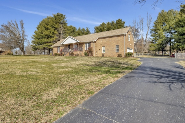 view of front of home with a garage, a front lawn, and covered porch