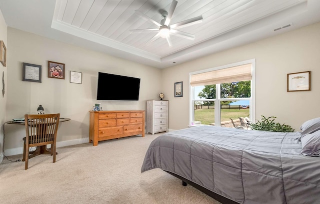 carpeted bedroom featuring wood ceiling, ceiling fan, and a raised ceiling