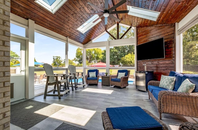 interior space with wood ceiling, ceiling fan, and vaulted ceiling with skylight