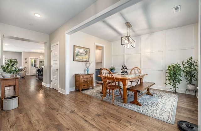 dining room with dark hardwood / wood-style flooring and a chandelier