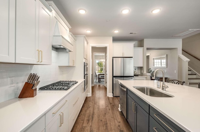 kitchen with dark hardwood / wood-style flooring, sink, stainless steel appliances, and white cabinets