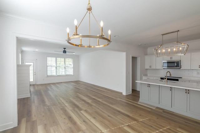 kitchen featuring decorative light fixtures, tasteful backsplash, white cabinets, range, and light wood-type flooring