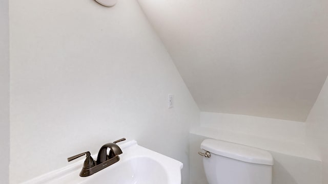 bathroom featuring vaulted ceiling, sink, and toilet