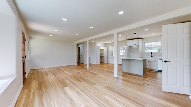 unfurnished living room with sink and light hardwood / wood-style floors