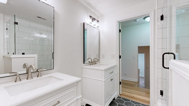 bathroom featuring vanity and a shower with door