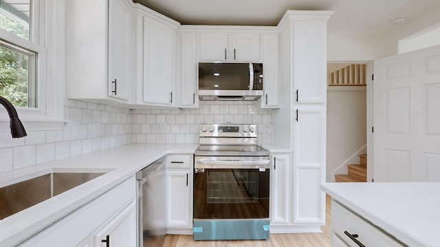 kitchen with stainless steel appliances and white cabinetry