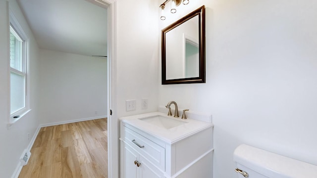 bathroom featuring vanity, toilet, and hardwood / wood-style floors