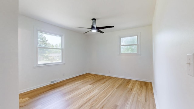 empty room with ceiling fan and light hardwood / wood-style flooring