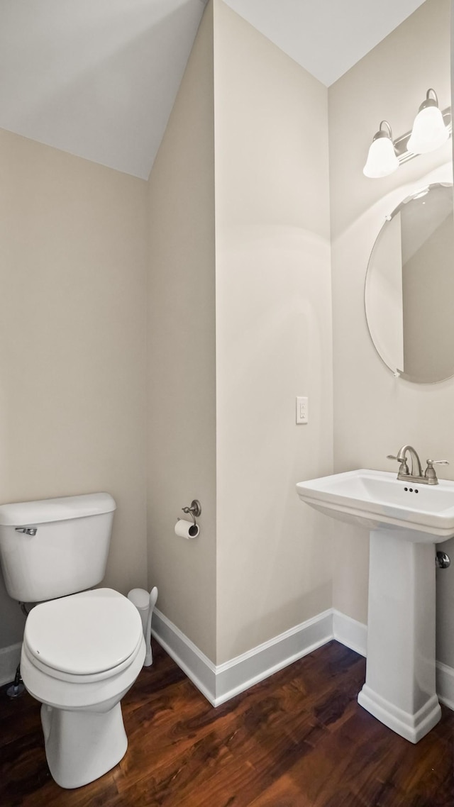 bathroom with lofted ceiling, hardwood / wood-style flooring, and toilet