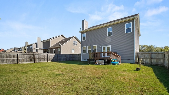 rear view of house featuring a deck and a lawn