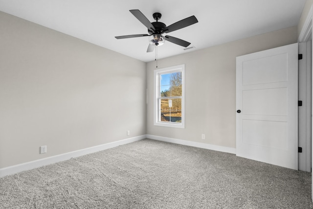 unfurnished room with carpet floors, visible vents, ceiling fan, and baseboards