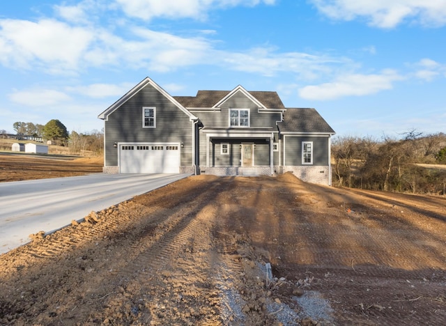 traditional home with a garage, concrete driveway, and covered porch