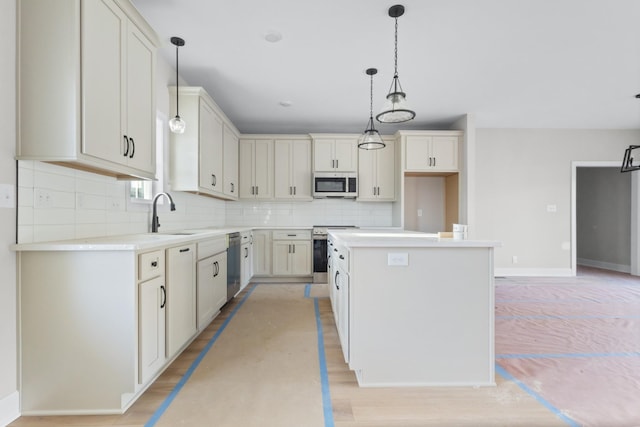 kitchen featuring a center island, stainless steel appliances, backsplash, light wood-style floors, and a sink