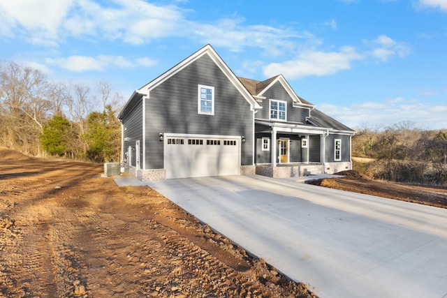 view of front of house featuring a garage, concrete driveway, and central AC