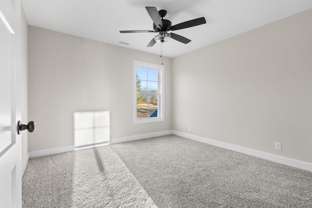 carpeted empty room with visible vents, a ceiling fan, and baseboards