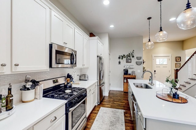 kitchen with sink, tasteful backsplash, pendant lighting, stainless steel appliances, and white cabinets