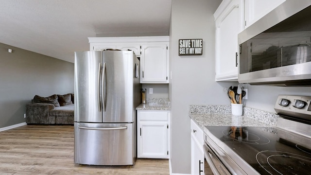 kitchen with white cabinetry, light hardwood / wood-style flooring, and stainless steel appliances