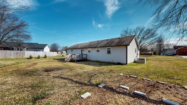 rear view of house with a wooden deck and a yard