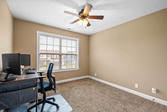 carpeted home office with a textured ceiling and ceiling fan