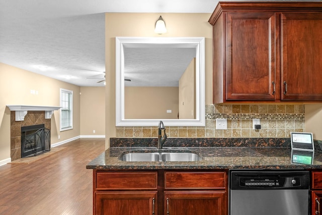 kitchen with sink, tasteful backsplash, stainless steel dishwasher, ceiling fan, and dark stone counters