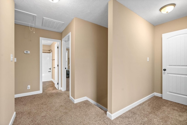 hall featuring carpet floors and a textured ceiling