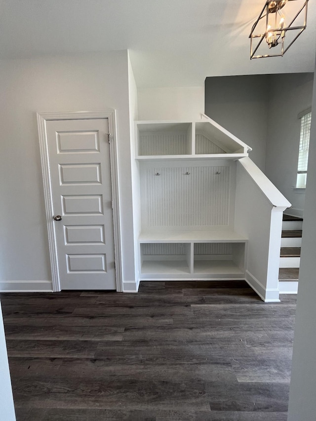 mudroom with dark wood-type flooring and a chandelier