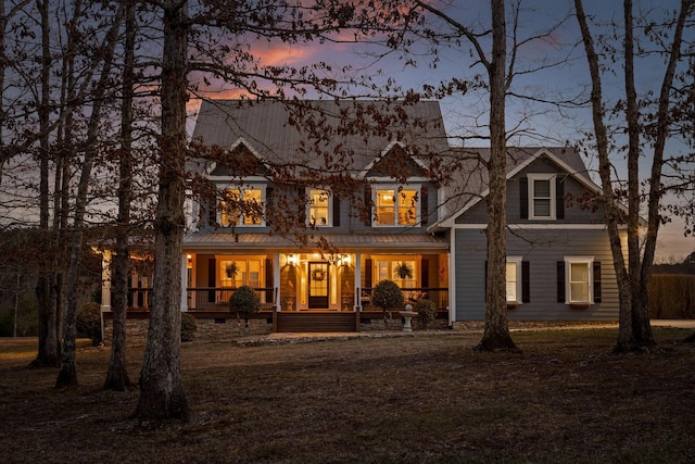 back house at dusk with covered porch