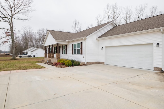 single story home featuring a garage, a front yard, and covered porch