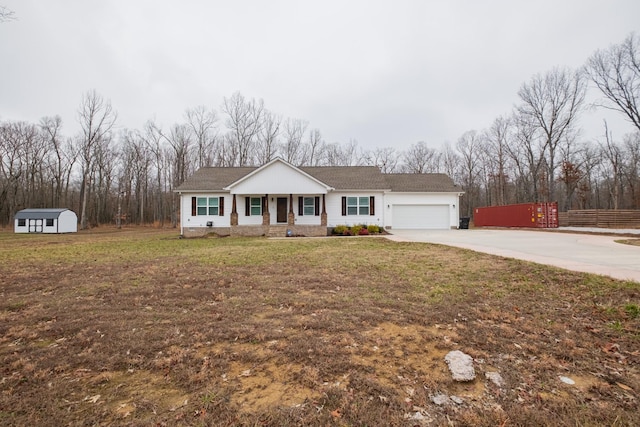 view of front of house with a garage, a front lawn, and a storage shed