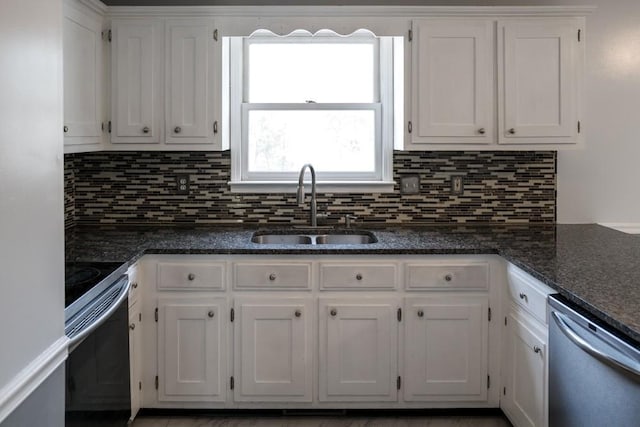 kitchen with sink, dark stone countertops, stainless steel appliances, tasteful backsplash, and white cabinets