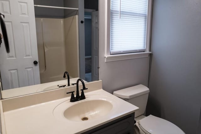 bathroom featuring vanity, a shower, and toilet