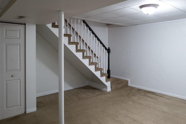 basement featuring carpet floors and a paneled ceiling