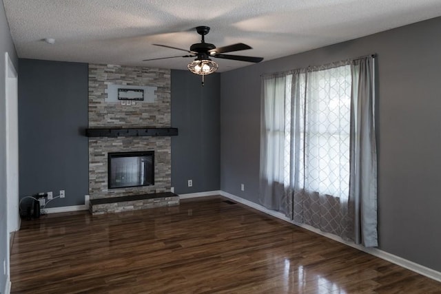 unfurnished living room featuring plenty of natural light, dark wood-type flooring, and a fireplace