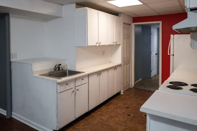 kitchen with sink, a paneled ceiling, white cabinets, and white refrigerator