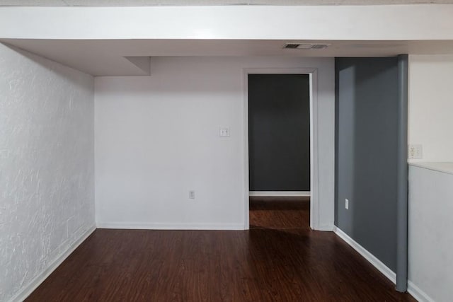 unfurnished room with dark wood-type flooring