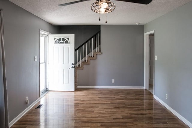 foyer entrance featuring ceiling fan, a textured ceiling, dark hardwood / wood-style floors, and a healthy amount of sunlight