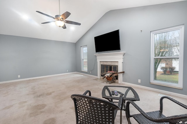 living room featuring lofted ceiling, a fireplace, light colored carpet, and ceiling fan