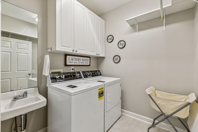 laundry room featuring cabinets, light tile patterned flooring, sink, and washing machine and clothes dryer