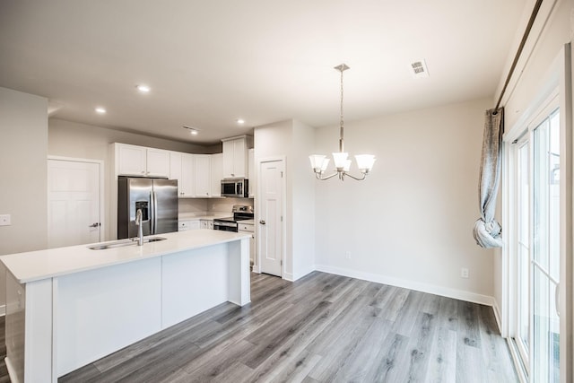 1335 Crescent Ridge Dr, Gallatin, TN 37066 - kitchen with white cabinetry, sink, hanging light fixtures, stainless steel appliances, and light hardwood / wood-style flooring