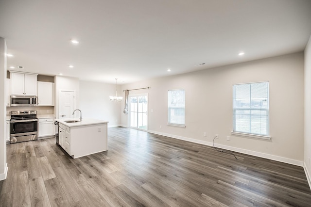 1335 Crescent Ridge Dr, Gallatin, TN 37066 - kitchen featuring white cabinetry, decorative light fixtures, appliances with stainless steel finishes, hardwood / wood-style flooring, and a kitchen island with sink