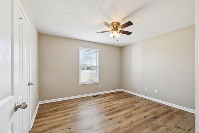 empty room featuring hardwood / wood-style flooring, ceiling fan, and a textured ceiling