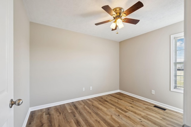 spare room with a textured ceiling, light hardwood / wood-style flooring, and ceiling fan