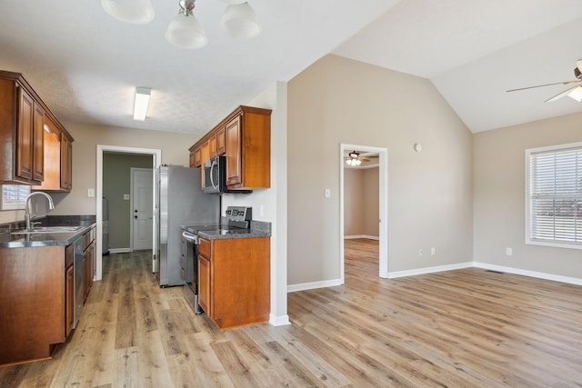 kitchen featuring vaulted ceiling, sink, ceiling fan, stainless steel appliances, and light hardwood / wood-style flooring