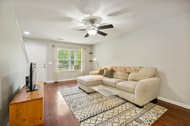 living room featuring dark wood-type flooring and ceiling fan