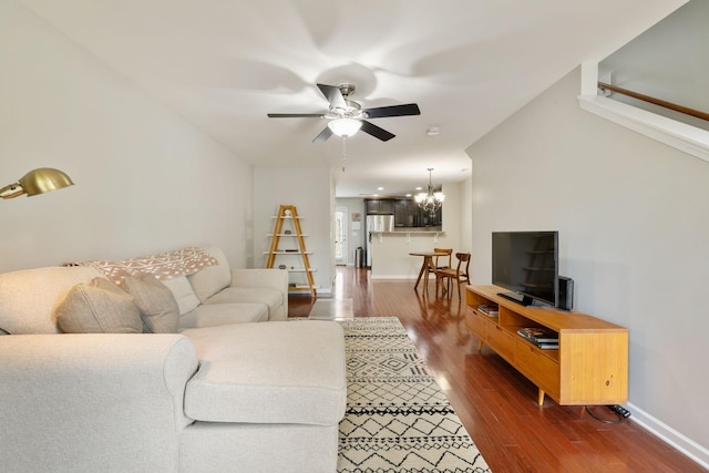 living room with hardwood / wood-style flooring and ceiling fan with notable chandelier