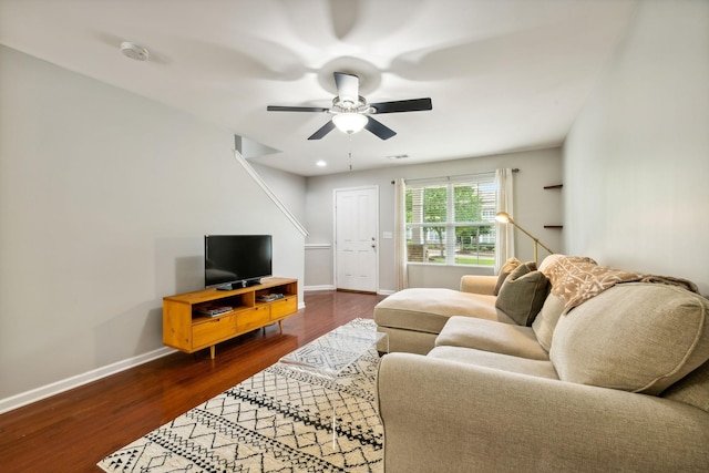 living room featuring dark wood-type flooring and ceiling fan