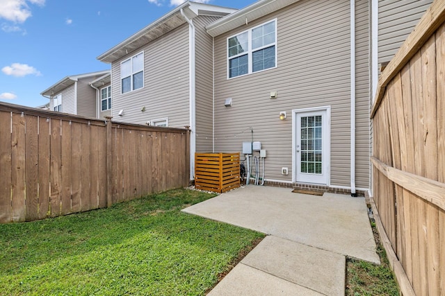 back of house featuring a lawn and a patio